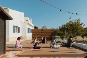a group of people sitting in a yoga class at Aldeia Caiçara Surf House in Sagres