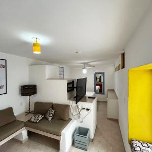 een woonkamer met een bank en een flatscreen-tv bij INMOTEGA - Suites TG in San Luis Potosí +76 foto's