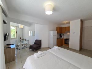 Un dormitorio con una cama blanca y una cocina. en Basilica Holiday Resort, en Pafos 45 fotos más