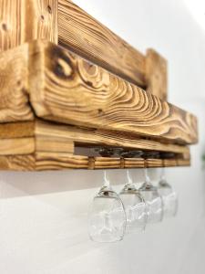 une rangée de verres à vin suspendus à un support en bois dans l'établissement Free Parking - La Corte House 53, à Castel di Sangro