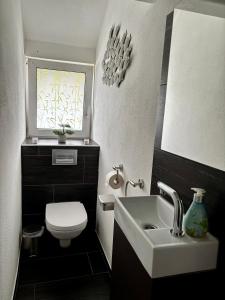 a bathroom with a sink and a toilet and a window at Ferienwohnung Micaela in Haselünne +37 photos