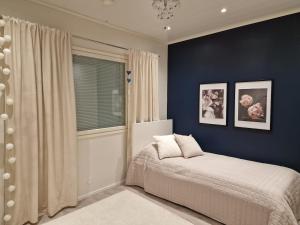 a bedroom with a bed and a blue wall at Spacious home near Santa Claus Village in Rovaniemi +26 photos