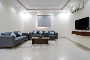a living room with couches and a flat screen tv at فندق الدار الرفيع in Riyadh