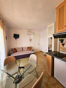 a kitchen and a living room with a table and chairs at Corfu Glyfada Menigos Resort 25 in Glyfada