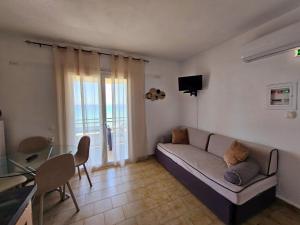 a living room with a couch and a table at Corfu Glyfada Menigos Resort 25 in Glyfada