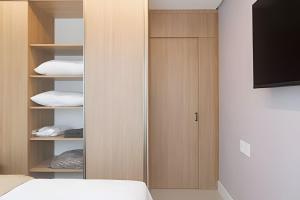 a bedroom with a closet with a bed and a television at Studio Premium em Torres - 450mts da Praia da Cal - Ar condicionado - Tv Smart - Wifi - Garagem - Aceita Pet in Torres