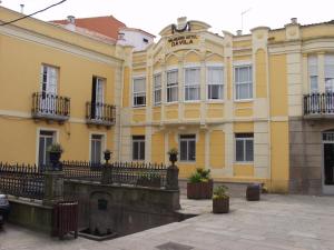 a yellow building with a fence in front of it at Senda Verde do Salnés in Portas