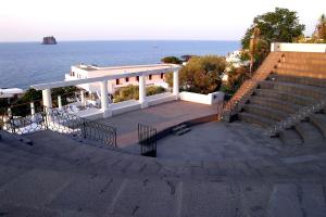 a white amphitheater with stairs next to the ocean at La Sirenetta Park Hotel in Stromboli