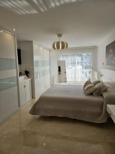 Un dormitorio blanco con una cama grande y una ventana. en Amazing Villa with swimming pool, en Torrent