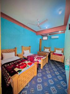 a bedroom with two beds and a blue wall at Dreamland Hotel Jaglot SAI Gilgit in Jaglot