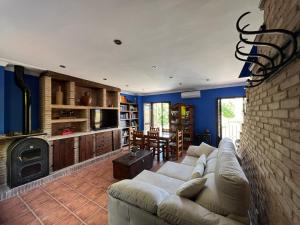 a living room with a couch and a brick wall at Casa Las Niñas in Olvera