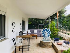 a patio with a couch and a table and chairs at Villa Leah Paralia Gerakinis in Gerakini