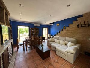 a living room with a white couch and a staircase at Casa Las Niñas in Olvera
