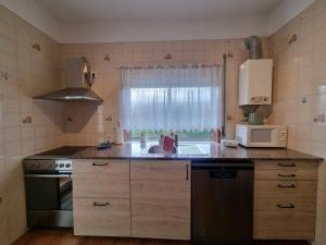 una piccola cucina con lavello e microonde di Zinha's Guest House a Moledo