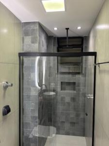 een douche met een glazen deur in een badkamer bij Studio Sezerdelo in Rio de Janeiro +4 foto's