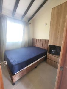 a bed in a room with a window at Cabaña Santa Alicia in Villa de Leyva