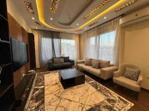 a living room with a couch and a tv at Modern 3 bedroom Penthouse in Cairo