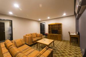 a living room with two couches and a television at Elegant Enchanted in Dhaka
