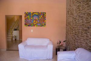 Una sala de estar con dos sillas blancas y un cuadro. en Brazil Inn Hostel, en Salvador 115 fotos más