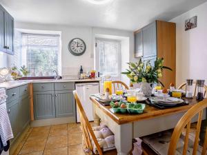 a kitchen with a table and a clock on the wall at 2 Bed in Aberporth 79199 in Felindre +19 photos