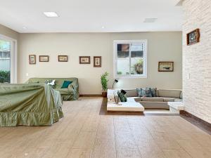 a living room with a couch and a table at 1 Suite - Churrasqueira - Piscina - AC - 200m do mar in Guarujá +13 photos