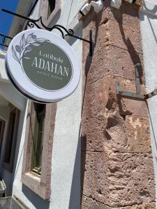 a sign hanging on the side of a building at Latibule Adahan Guest House in Ayvalık