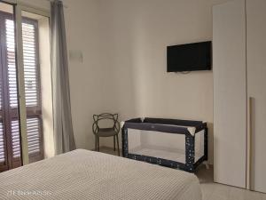 una camera da letto con un letto e una TV a parete di Punta mare a Marsala