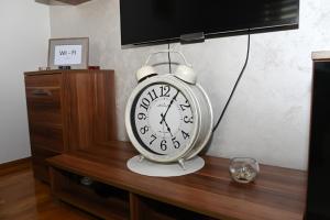 a clock sitting on top of a wooden table at Apartman TEA Trebinje in Trebinje