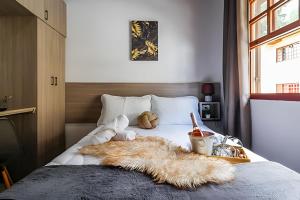 Una cama con una manta peluda y animales de peluche encima. en Apê Inteiro| 2Qts| Estacionamento| Wi-Fi 350| Pet Friendly| Ao Lado do Parque das CEREJEIRAS, en Campos do Jordão