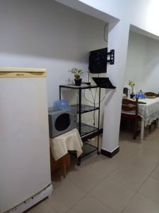 a room with a tv and a table with a bed at Eliogemi Gardens Guests House in Gbawe