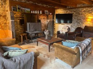a living room with two couches and a tv at La Roulière en Aubrac in Montpeyroux