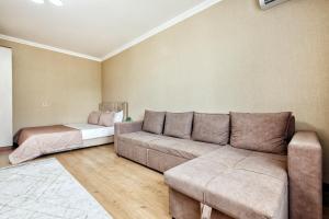 a living room with a couch and a bed at 1-комнатная квартира Иманбаевой 2, ЖК Байконыс in Astana