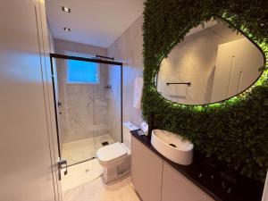 a bathroom with a mirror and a toilet and a sink at Studios Heaven in Gramado +57 photos