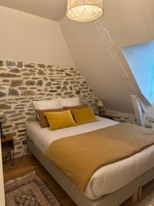 a bedroom with a bed with a stone wall at La Roulière en Aubrac in Montpeyroux +60 photos