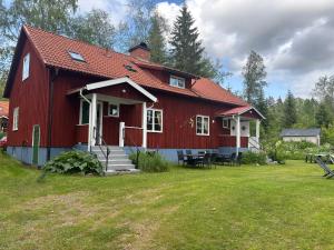 a red house with a red roof at Liljekonvalj in Filipstad