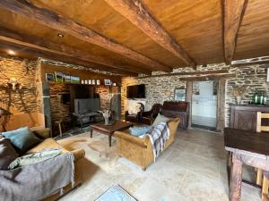 a living room filled with furniture and a stone wall at La Roulière en Aubrac in Montpeyroux