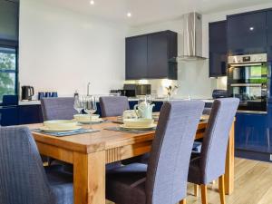 a kitchen and dining room with a wooden table and chairs at Druids Knowe in Tarfside +16 photos