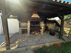 にあるPeaceful villa Terezaの庭の木造屋根の下にある暖炉