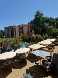 a group of tables and umbrellas next to a pool at Residensia Bahami in Sunny Beach