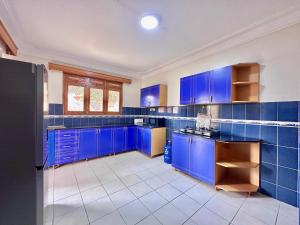 a blue kitchen with blue cabinets and tile floors at Green Haven Nsambya, Kampala in Nalakonge