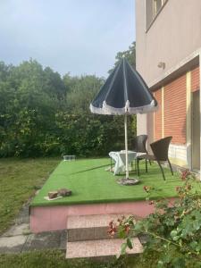 a patio with an umbrella and a table and chairs at Soba s pogledom na Dravski Park u Varaždinu in Varaždin +2 photos