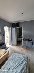 a living room with a couch and a television at Pensjonat przy plaży in Wielen Zaobrzanski