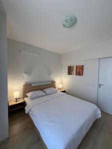 a bedroom with a large white bed and two lamps at Apartment D25 Pomorie in Pomorie