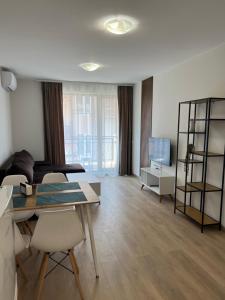 a living room with a table and chairs and a couch at Apartment D25 Pomorie in Pomorie