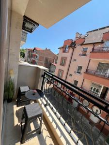 a balcony with a table and chairs and a building at Apartment D25 Pomorie in Pomorie