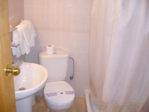 a bathroom with a white toilet and a sink at Hostal Casa Grande in Baza