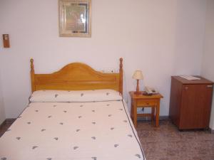 a bedroom with a bed and a table with a nightstand at Hostal Casa Grande in Baza