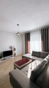 a living room with a couch and a tv at Leo apartaments with sea view in Durrës