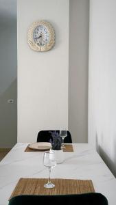 a table with two glasses and a clock on the wall at Leo apartaments with sea view in Durrës