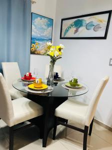 Un comedor con una mesa de cristal y sillas. en Nueva san Miguel, en San Miguel